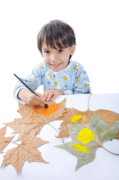 A little sweet boy painting on leaves — Stock Photo, Image