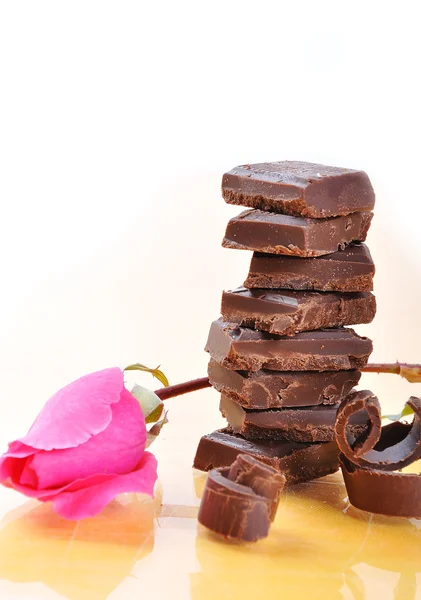 Schokolade, Tisch, Stücke und rosa Rose o — Stockfoto