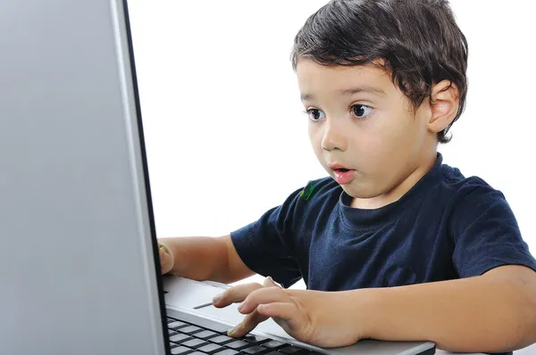Ein kleines süßes Kind mit einem Laptop isoliert lizenzfreie Stockbilder