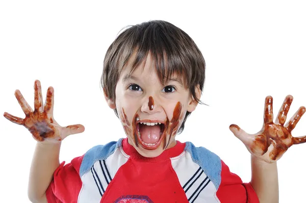 Weinig schattige jongen met chocolade op gezicht een Stockfoto