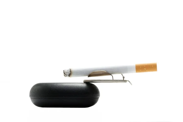 Сигарета на попільничці над білим — стокове фото