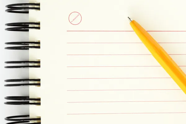 Folha limpa de notebook com caneta laranja — Fotografia de Stock