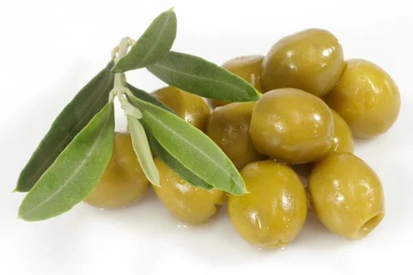 Zelené olivy s olivovou ratolestí — Stock fotografie