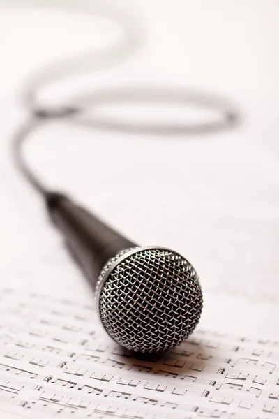 Microphone on scores — Stock Photo, Image