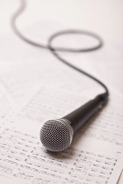 Microphone on scores — Stock Photo, Image