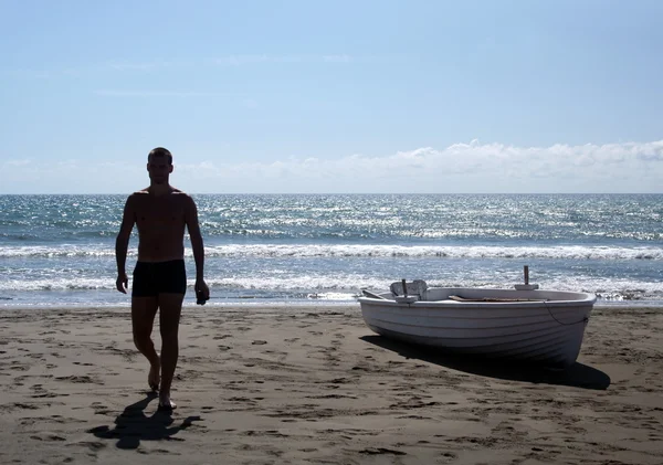 Adam, yüzme sonra kumsalda yürür. — Stok fotoğraf