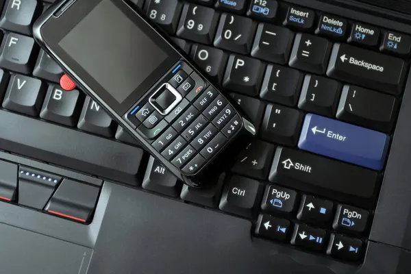 Mobiele telefoon en laptop toetsenbord — Stockfoto