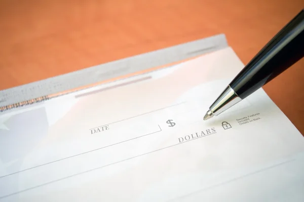 Finansiella begrepp check och penna — Stockfoto