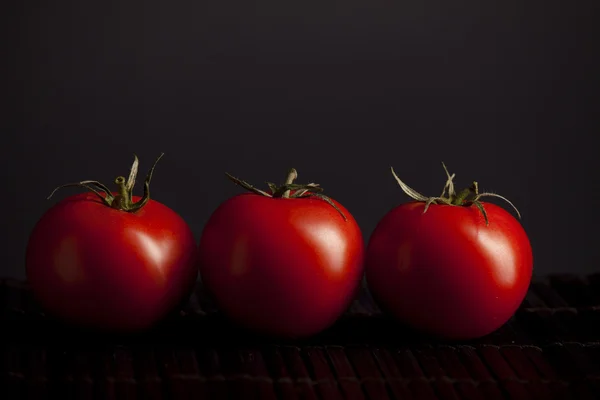 Pomidory na czarnym tle — Zdjęcie stockowe