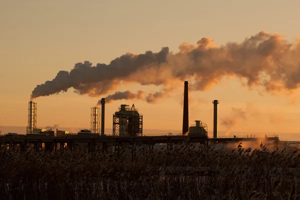 stock image Smoke rising from factory at sunset