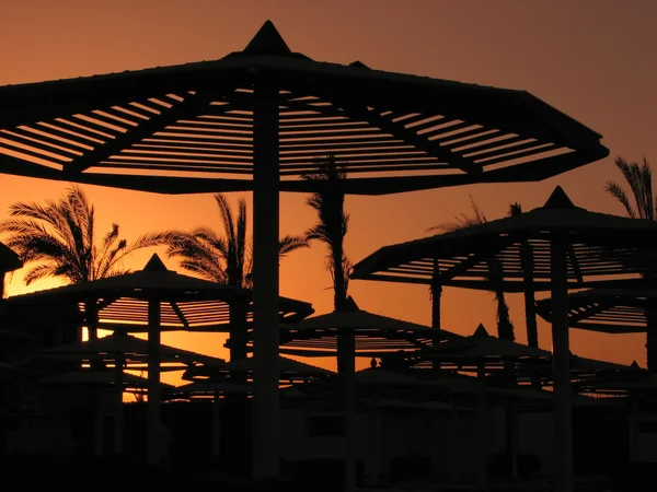 血腥夕阳与海滩遮阳伞 — 图库照片