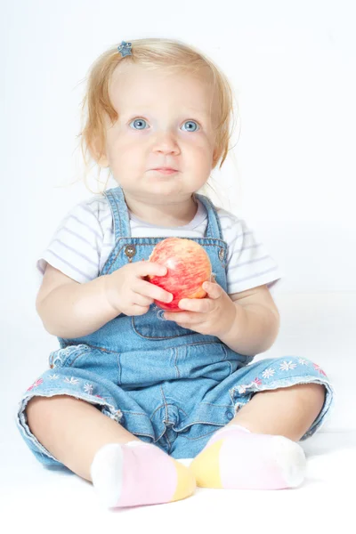 Сидящий ребенок с яблоком — стоковое фото