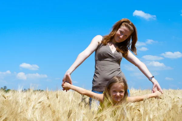 Mãe com filha no campo de trigo — Fotografia de Stock
