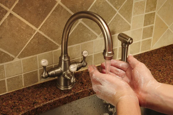 Lavarse las manos con jabón bajo agua corriente — Foto de Stock