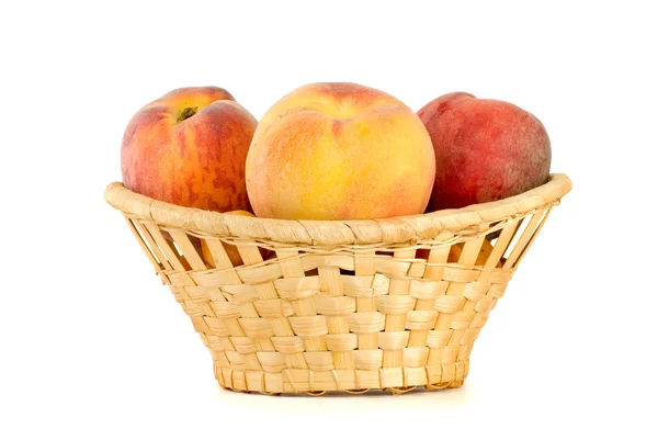 Three tasty peaches in wicker basket — Stock Photo, Image