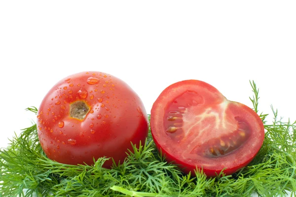 Ripe tomato and half over some dill — Stock Photo, Image