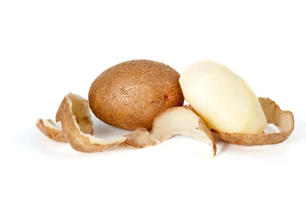 Whole and peeled potatoes and some peel — Stock Photo, Image