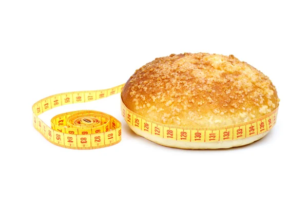 Fresh bun and measurement tape — Stock Photo, Image