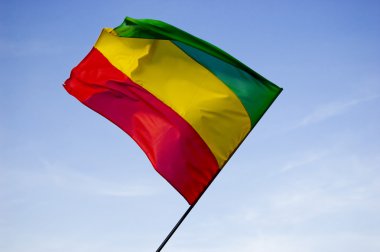 Reggae flag over blue sky clipart