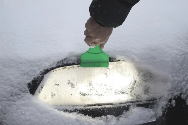 Quitar la nieve de la lámpara del coche —  Fotos de Stock