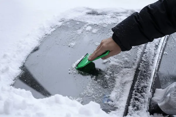 Quitar la nieve del parabrisas del coche — Foto de Stock