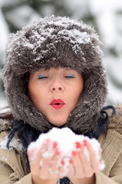 Jovem mulher brincando na neve — Fotografia de Stock
