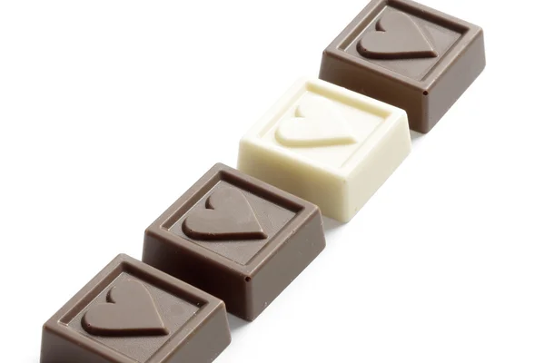 Quatro chocolates com os corações pequenos — Fotografia de Stock