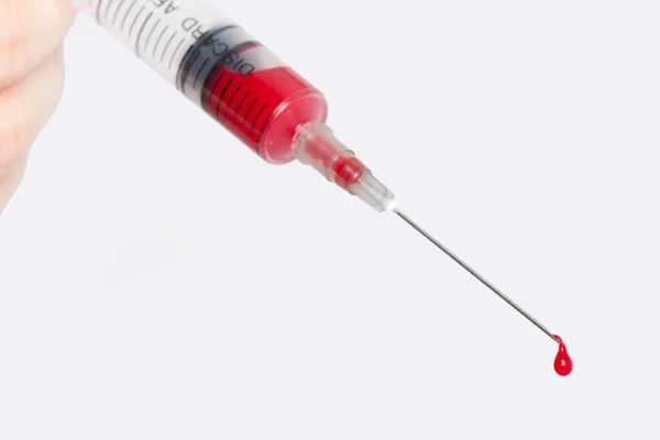 Syringe with blood in hand Royalty Free Stock Images