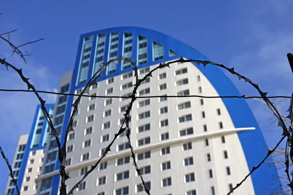 Barbed wire and skyscraper — Stock Photo, Image