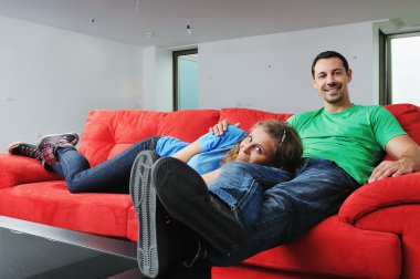 Mutlu çift kırmızı kanepede rahatlatıcı
