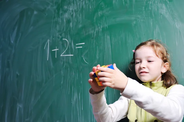 Счастливая школьница на уроках математики — стоковое фото