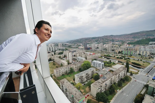 Frau schaut auf Balkon — Stockfoto