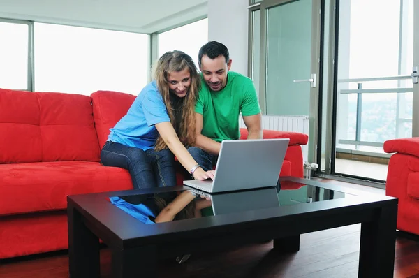 Ευτυχισμένο ζευγάρι να διασκεδάσουν σε φορητό υπολογιστή στο σπίτι — Φωτογραφία Αρχείου