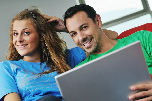 Heureux couple s'amuser sur ordinateur portable à la maison — Photo
