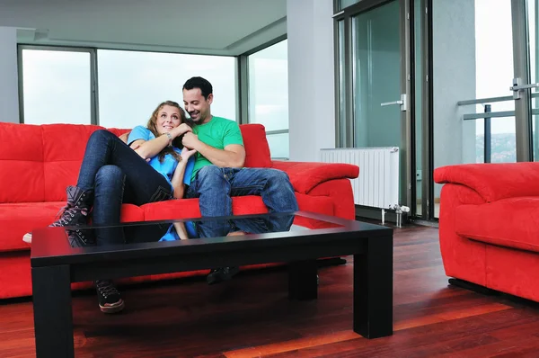 Couple heureux relaxant sur canapé rouge — Photo