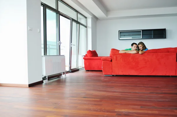 Szczęśliwa para relaksujący na czerwonej kanapie — Zdjęcie stockowe