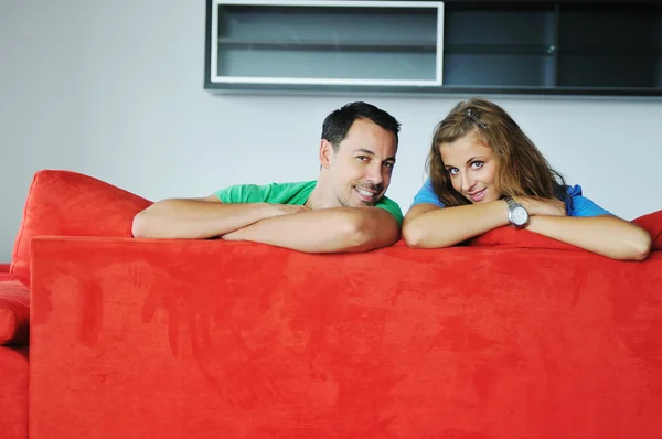 Mutlu çift kırmızı kanepede rahatlatıcı — Stok fotoğraf