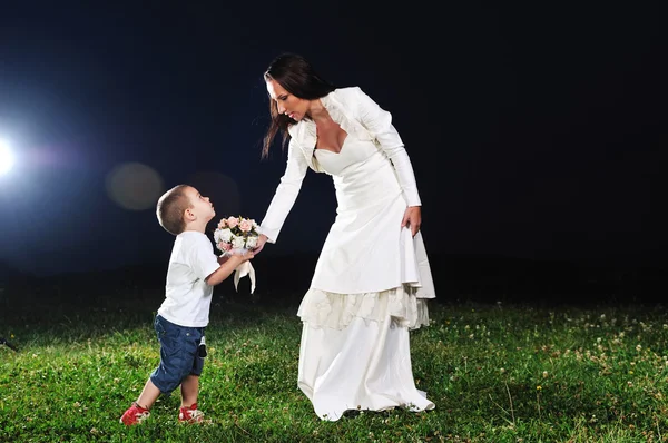 Невеста дарит ребенку цветок — стоковое фото