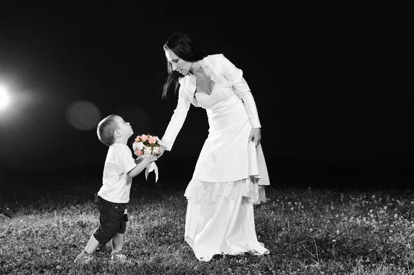 Невеста дарит ребенку цветок — стоковое фото