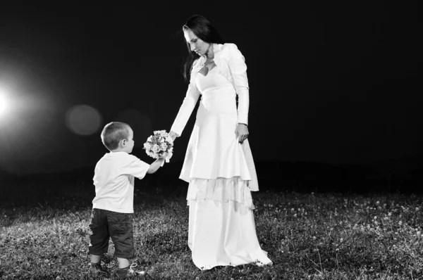 Bride giving child flower — Stock Photo, Image