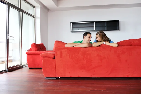 Szczęśliwa para relaksujący na czerwonej kanapie — Zdjęcie stockowe
