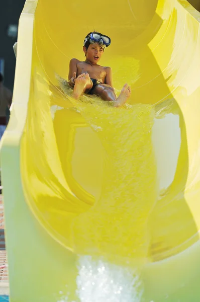 Fille avoir du plaisir sur la glissière d'eau à la piscine extérieure — Photo