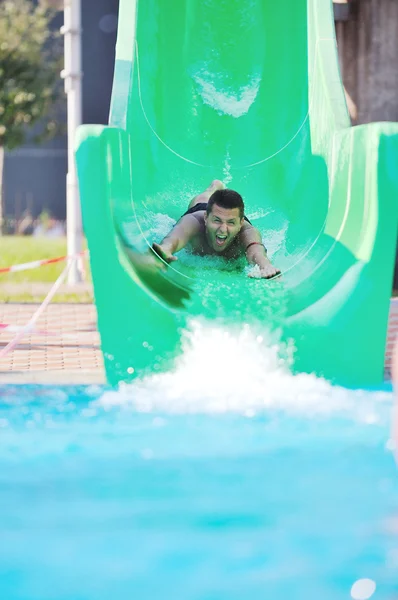 Ragazza divertirsi sullo scivolo d'acqua a nuoto all'aperto — Foto Stock