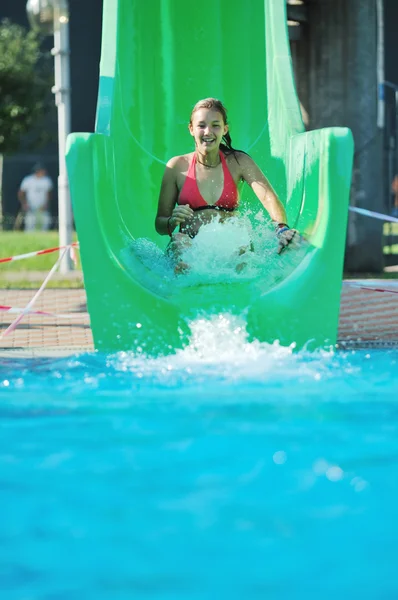 Meisje hebben plezier op Wasser Rutsche op buiten swimmin — Stockfoto