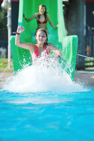 Lány szórakozni a vízi csúszda a szabadtéri foglalkozok — Stock Fotó