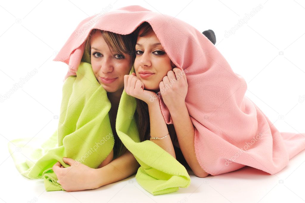 Young girls under blanket smile