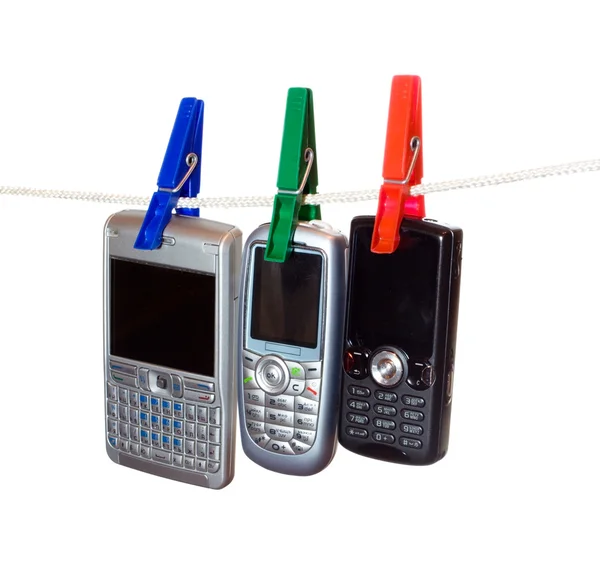 Três telefones celulares em uma linha de roupa 2 — Fotografia de Stock