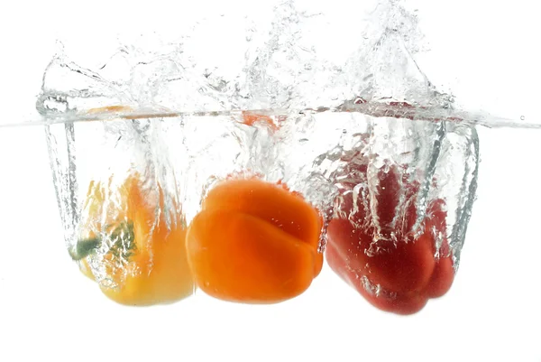Close-up three peppers falling in water — Stock Photo, Image