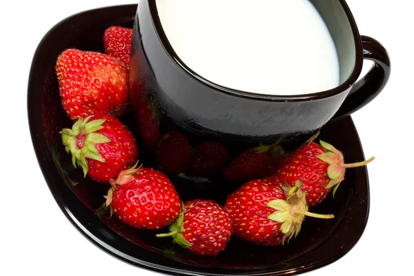 Jordgubbar och svart kopp mjölk — Stockfoto