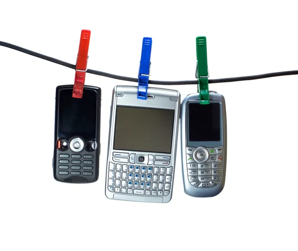 Tres teléfonos móviles en una línea de ropa —  Fotos de Stock